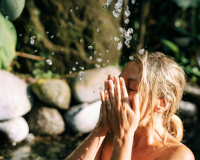 girl washing face under waterfall in forest Yan Krukau from Pexels via Canva
